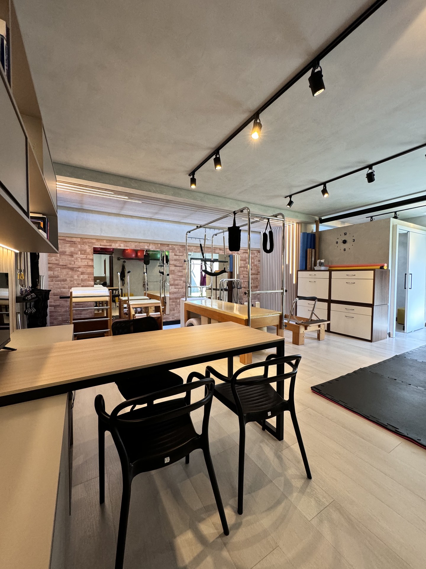 Visão ampla do estúdio com aparelhos e recepção no Lya Reis Studio de Pilates em Campo Grande