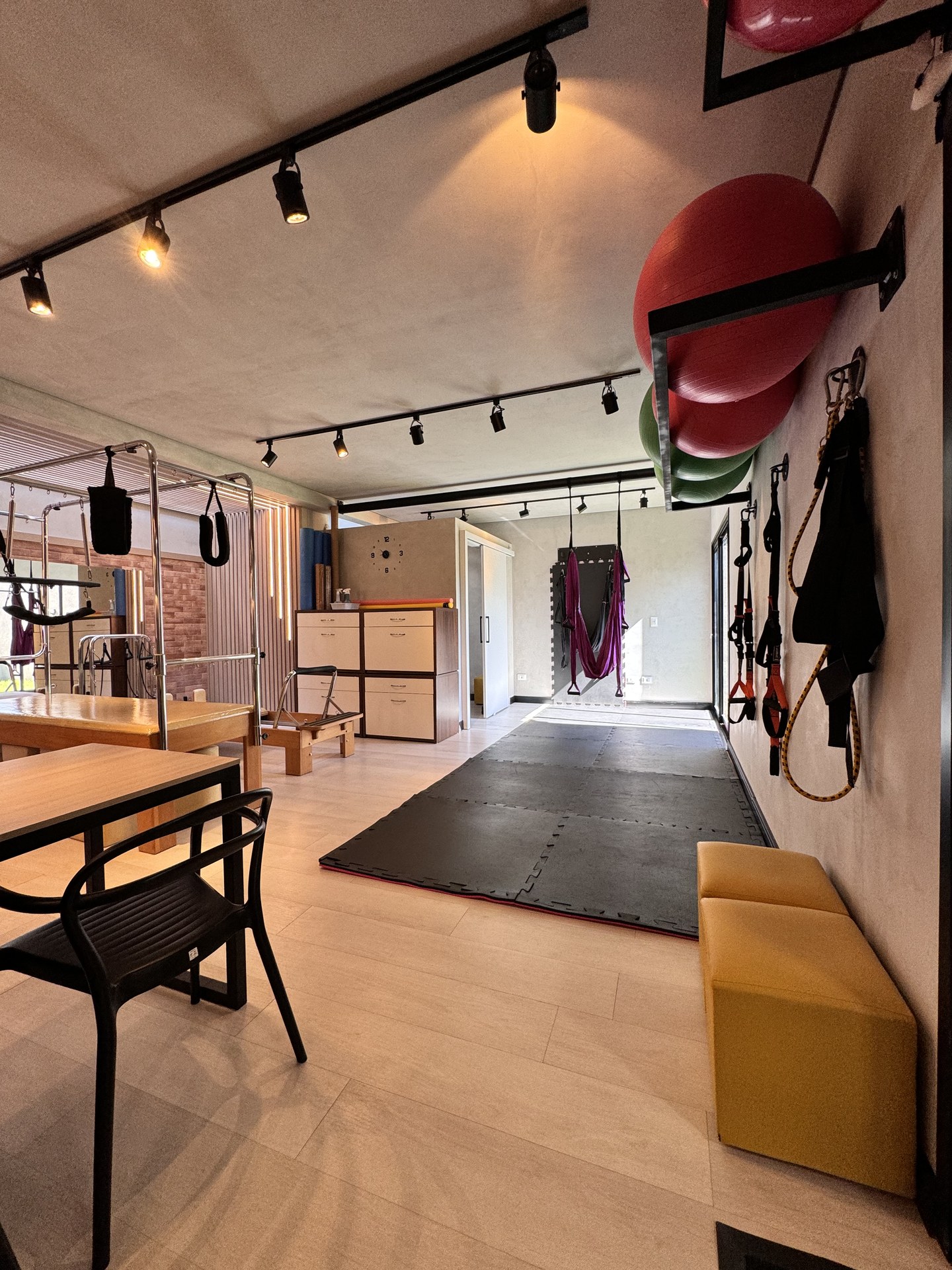 Espaço de Pilates Aéreo com columpio suspenso, tatame e acessórios no Lya Reis Studio de Pilates